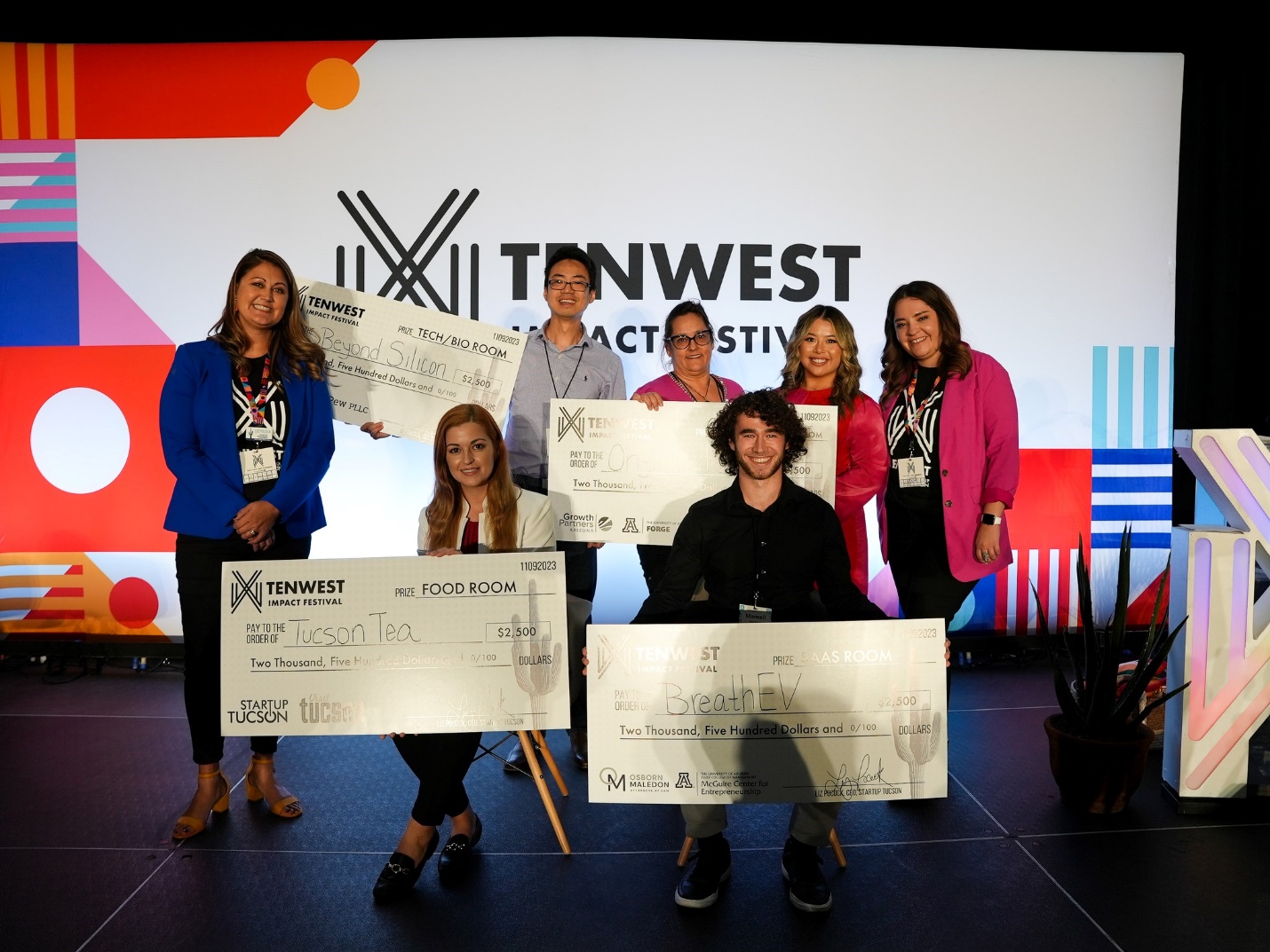 A group of people holding large check

Description automatically generated